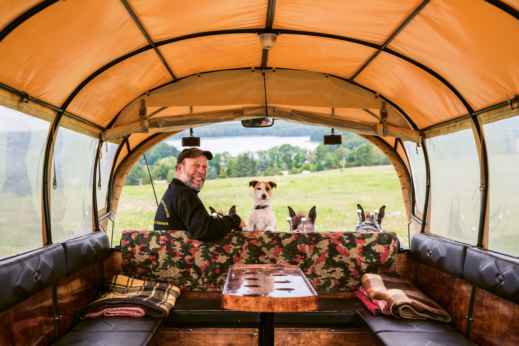 Mann mit Hund in Planwagen